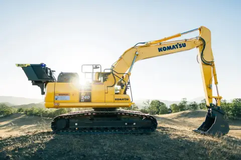 Żółta koparka Komatsu PC 240 LC na wzgórzu. Idealna do leasingu maszyn budowlanych.